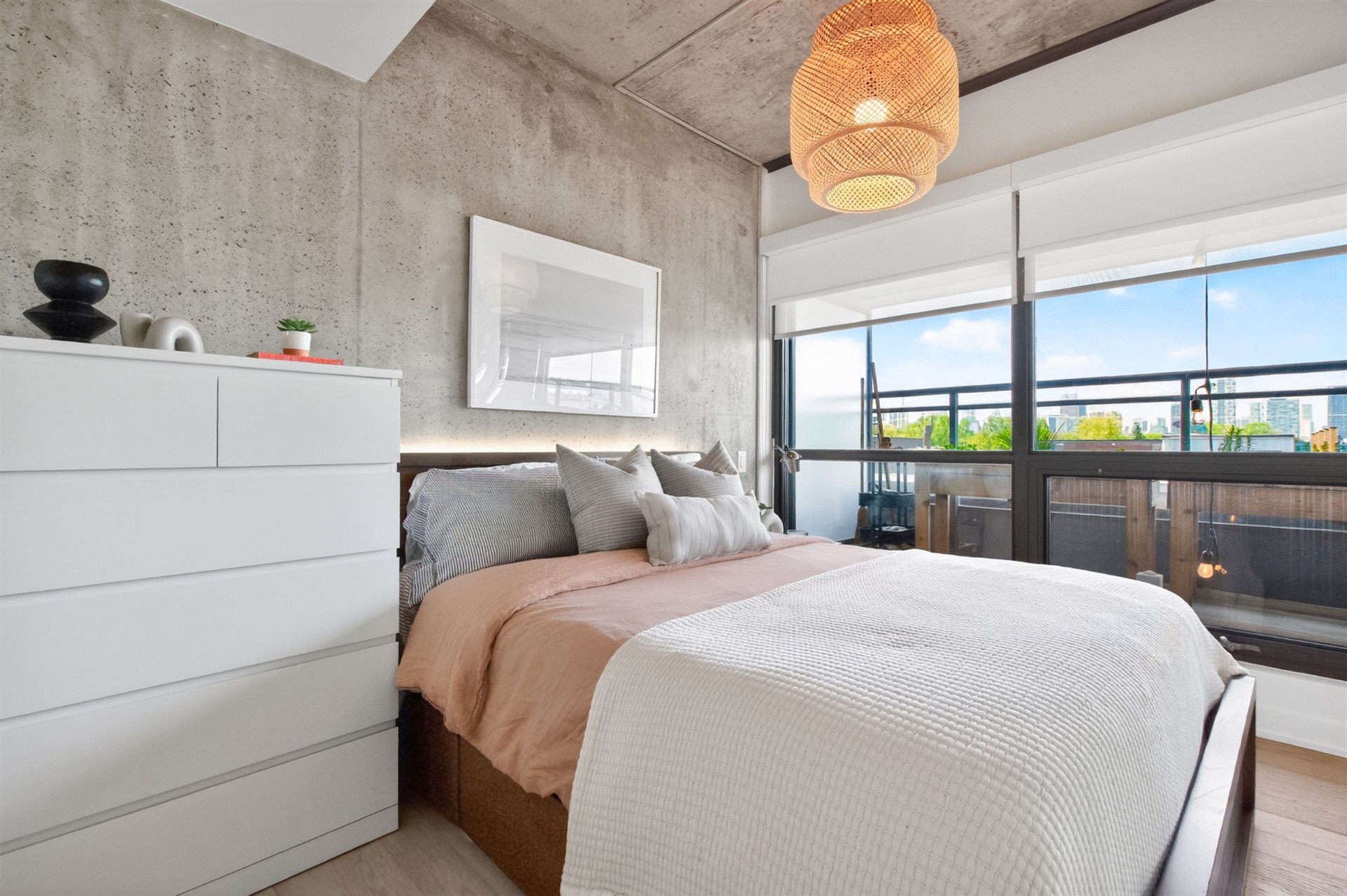 Primary bedroom with concrete feature wall and skyline view