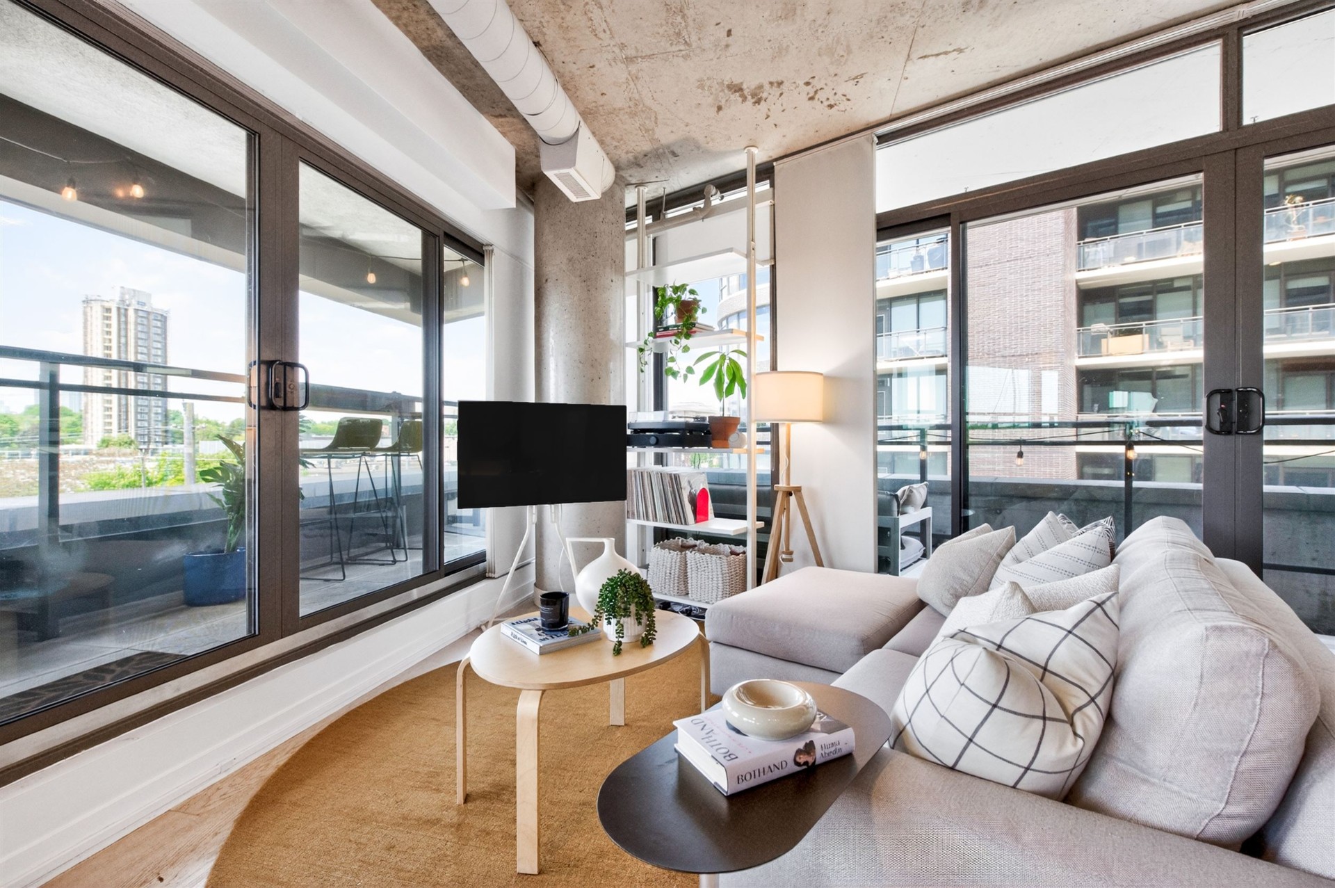 Living room corner with wraparound windows and city view