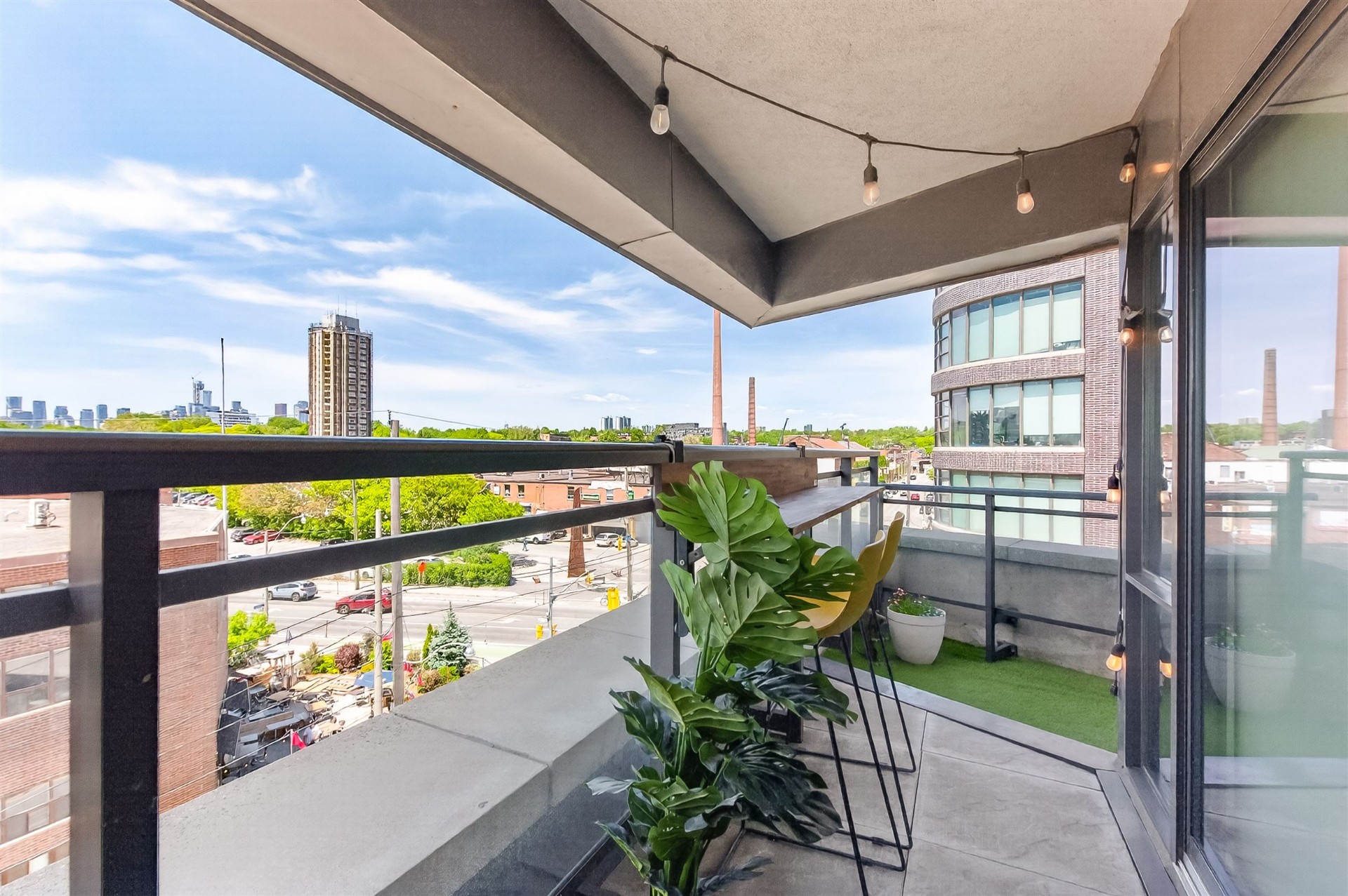 Terrace bar seating with monstera plants and skyline view