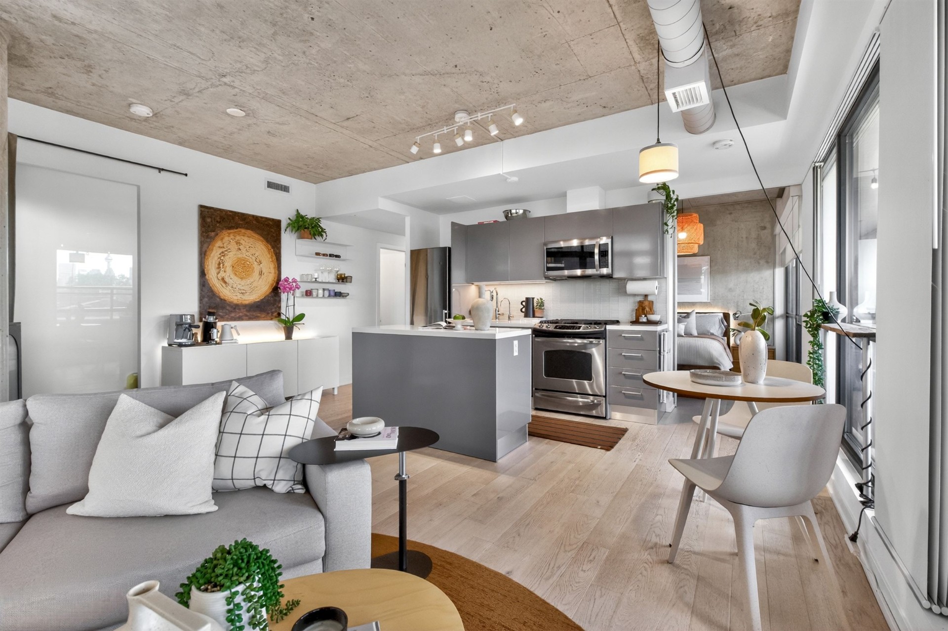 Open-concept living, kitchen and bedroom with concrete ceiling