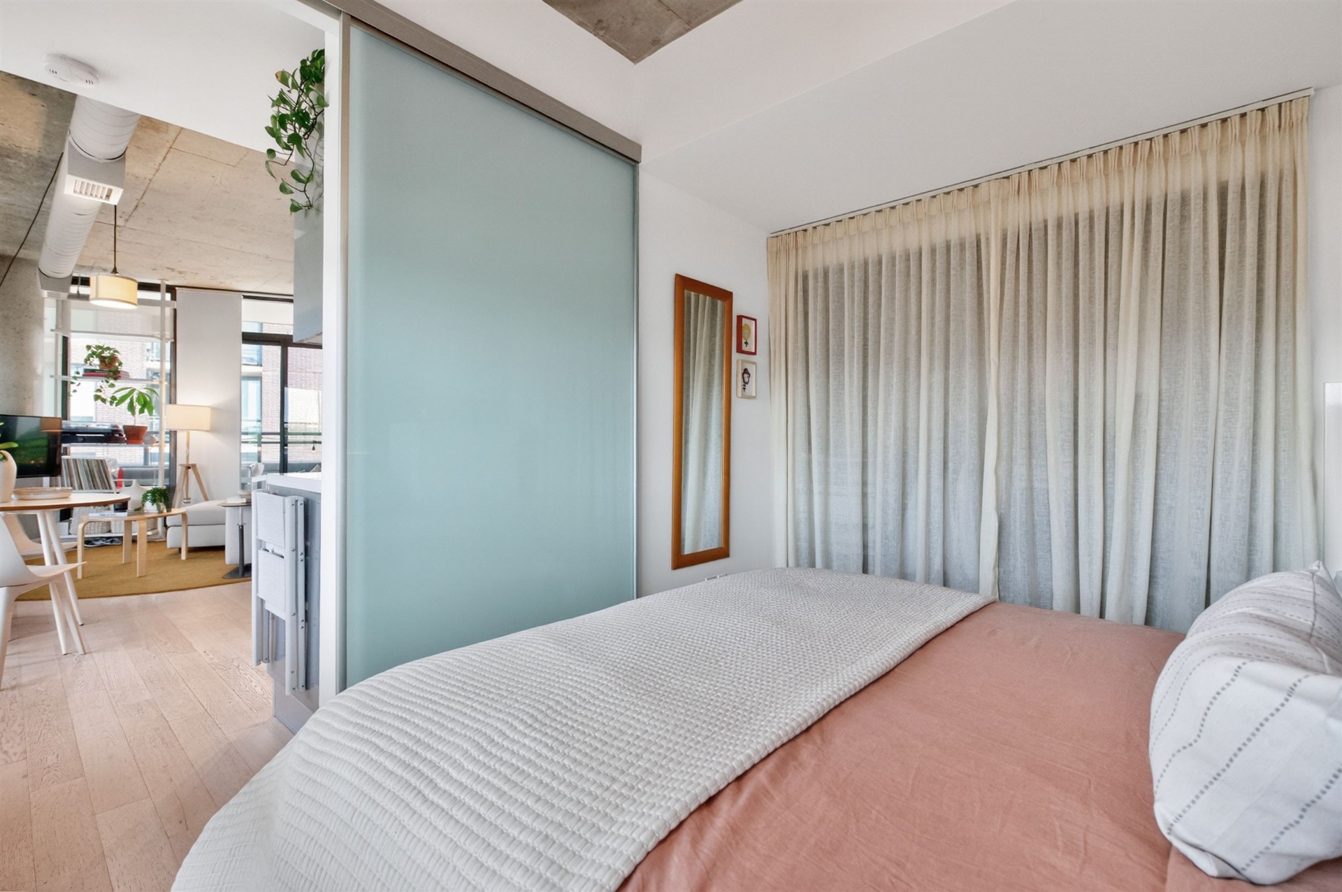 Primary bedroom with frosted glass sliding door to living area