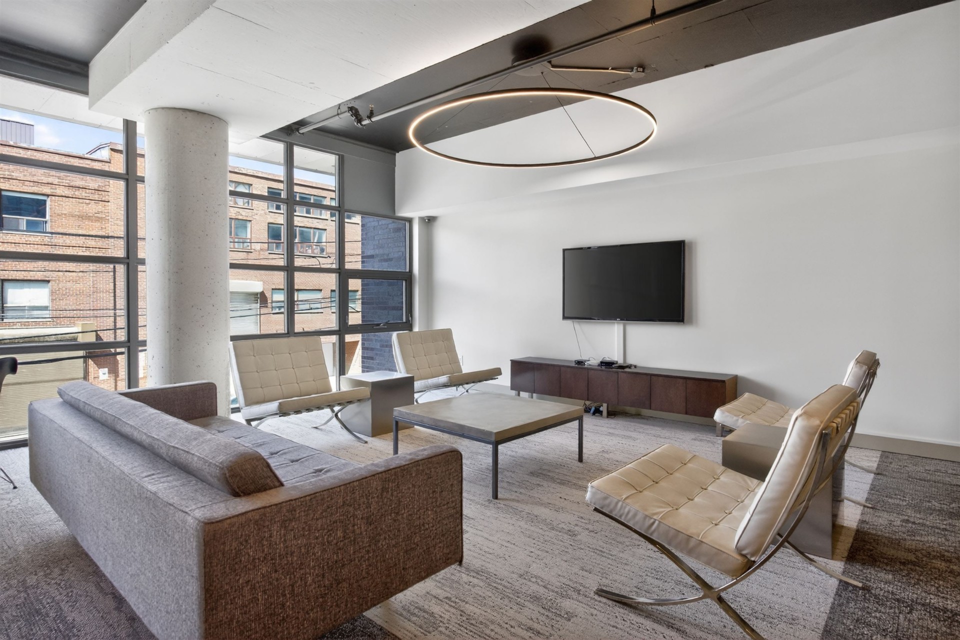 Amenity lounge with Barcelona chairs, sofa and TV