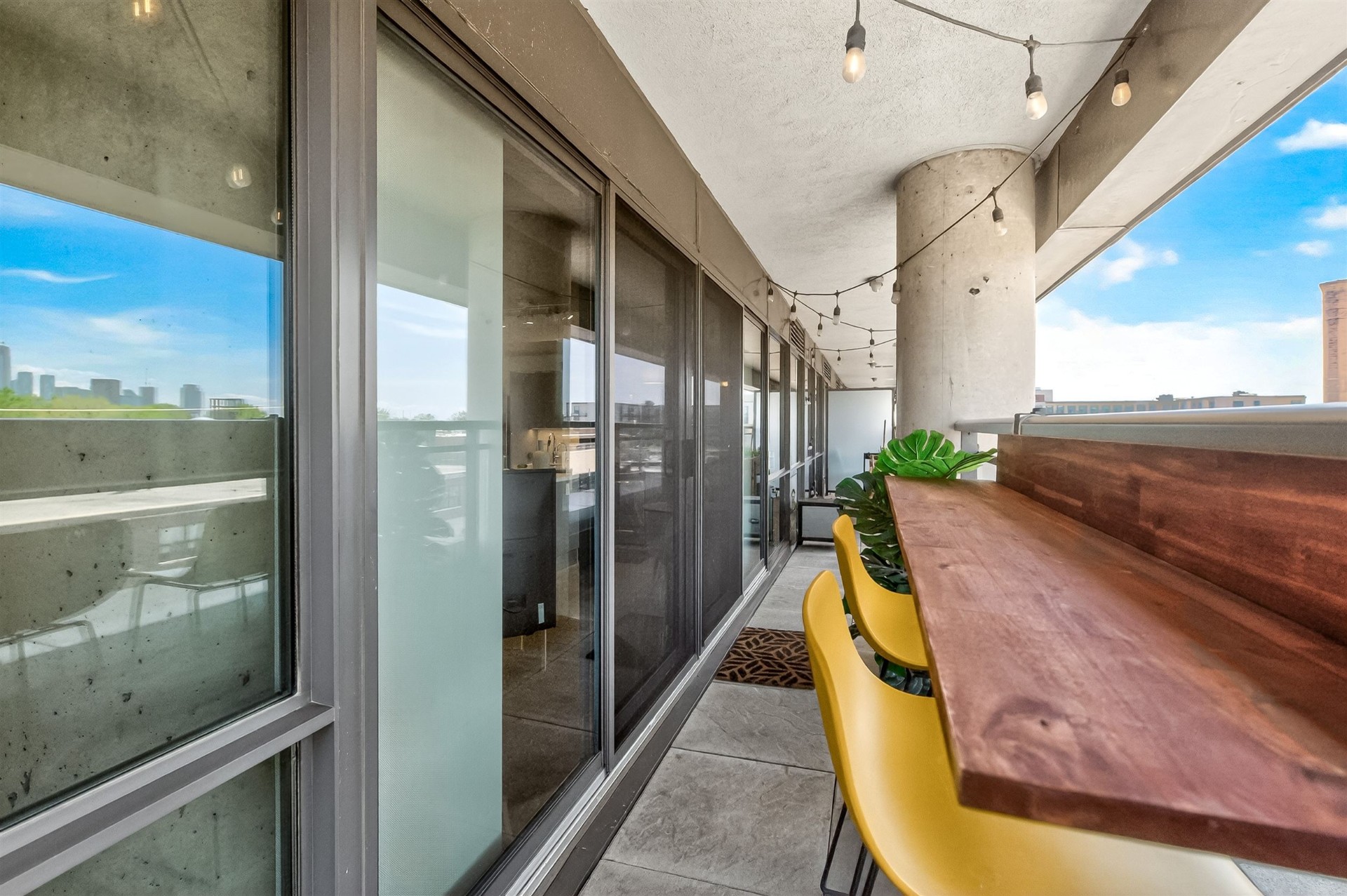 Terrace bar counter with yellow stools and string lights